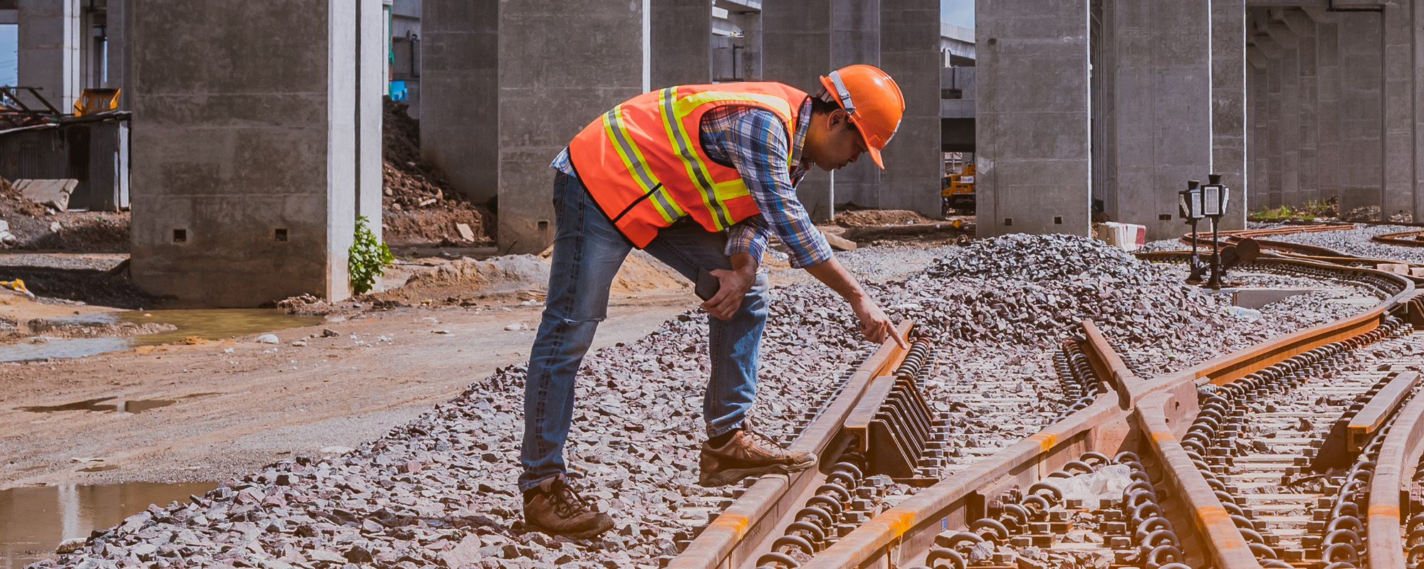 A engineer under inspection and checking construction process railway work on rail train station by Blueprint on hand