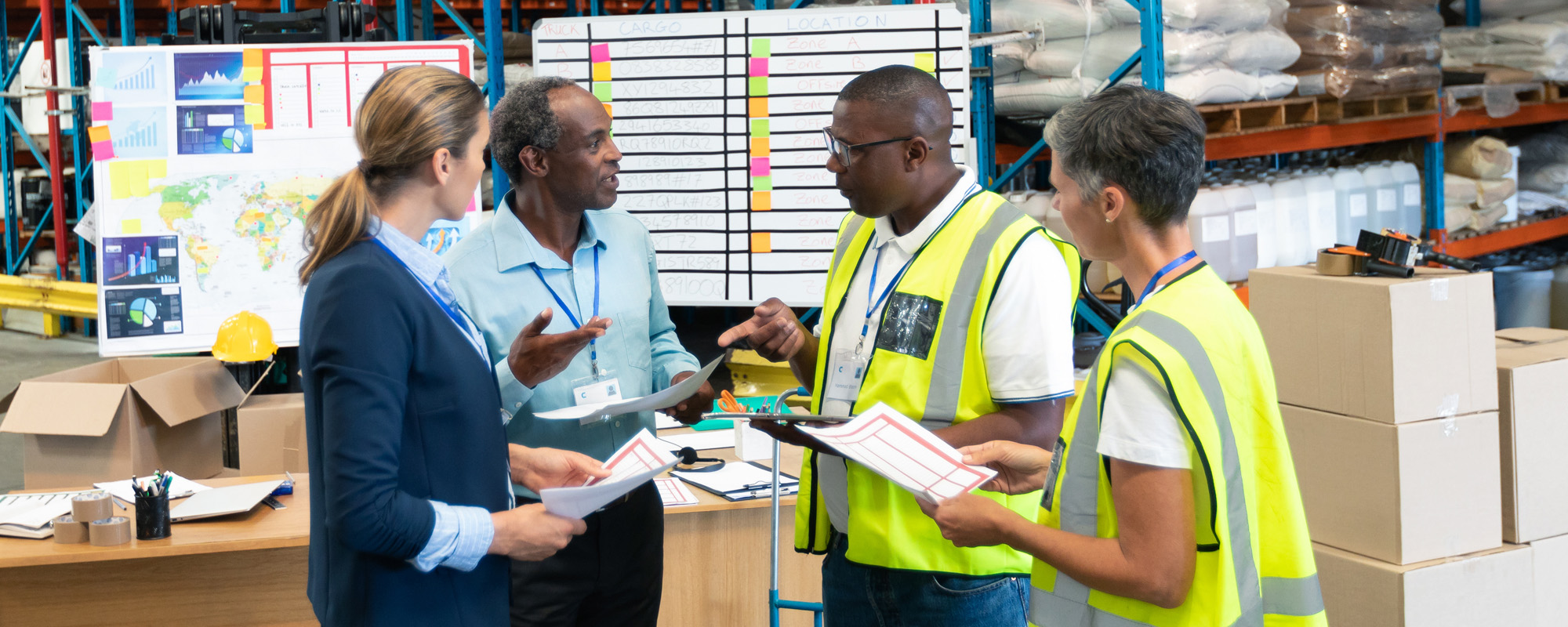 Staffs discussing over document in warehouse