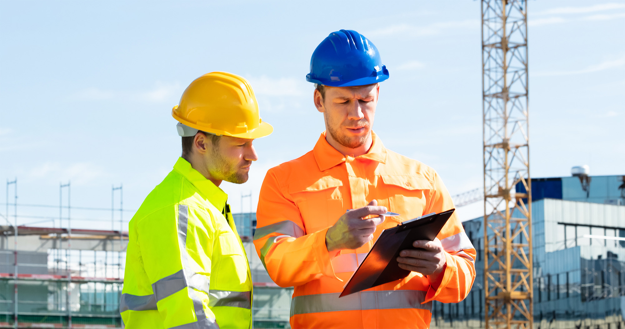 Two Male Engineers With Clipboard Working At Construction Site