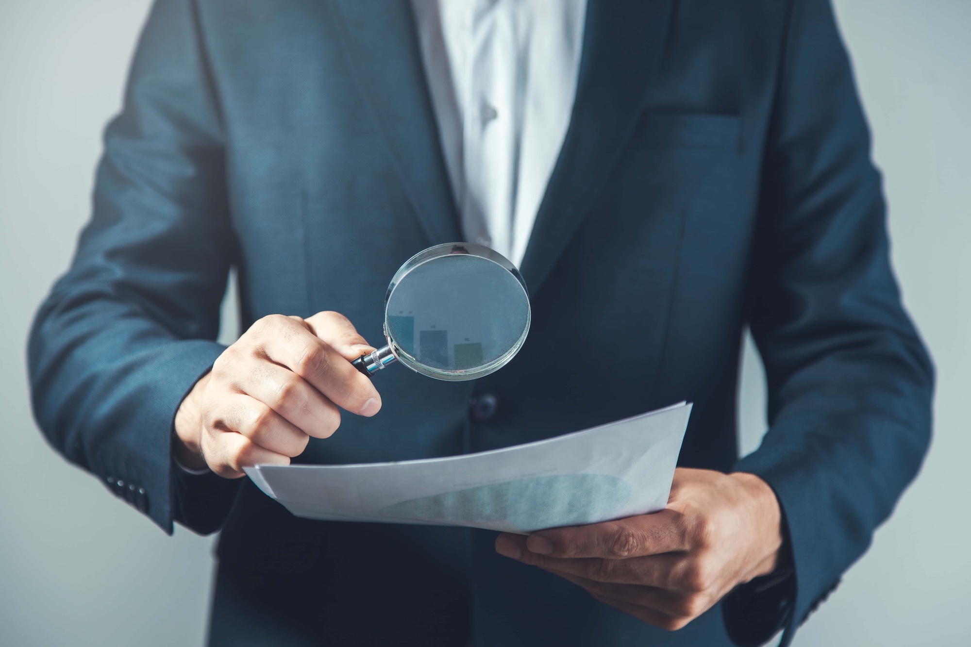 man hand magnifier and document